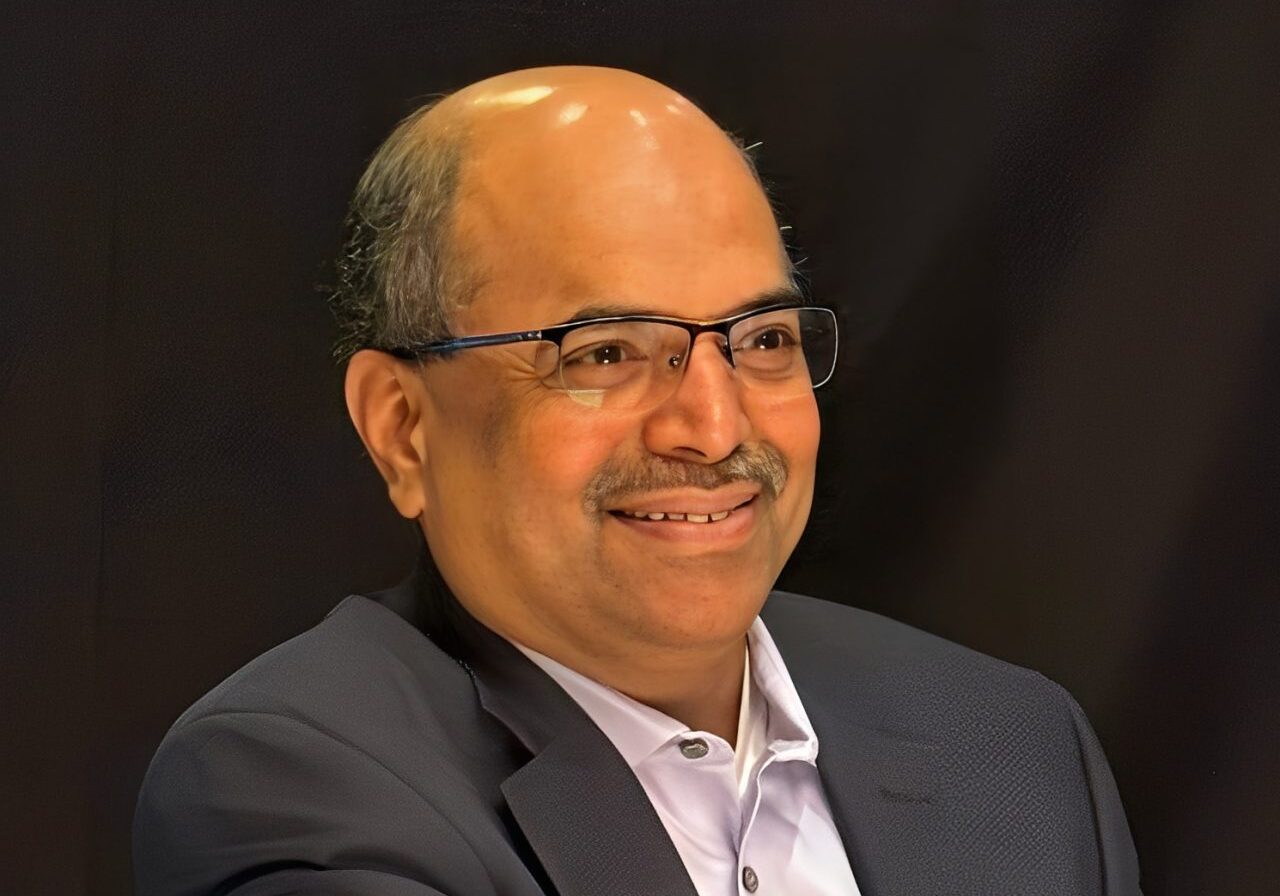 Smiling man wearing glasses and a suit.