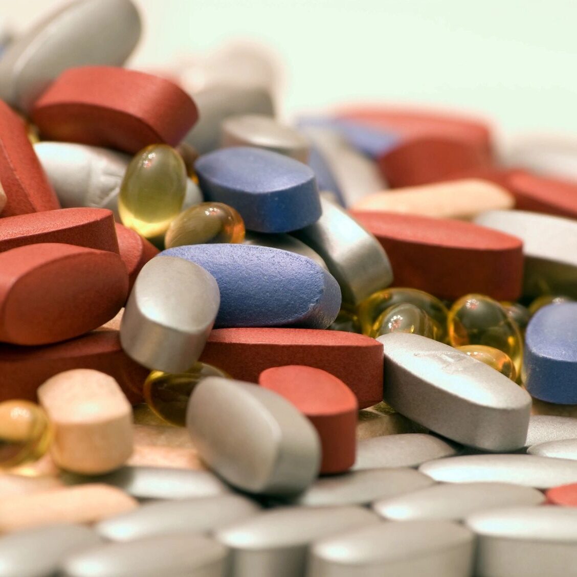 Various colorful pills and capsules scattered.